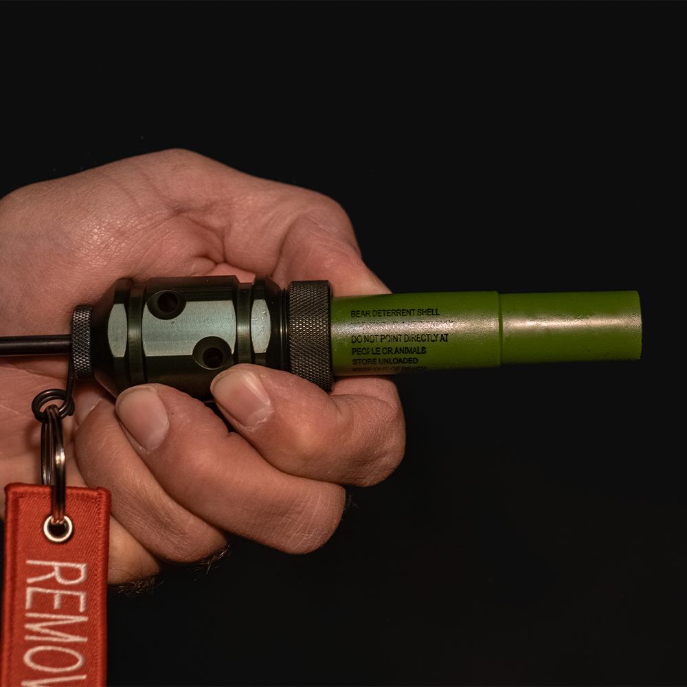 Hand holding the Fith Ops Gen4 2-in-1 Rescue Device with OD Green Waterproof Sight and Sound Shells