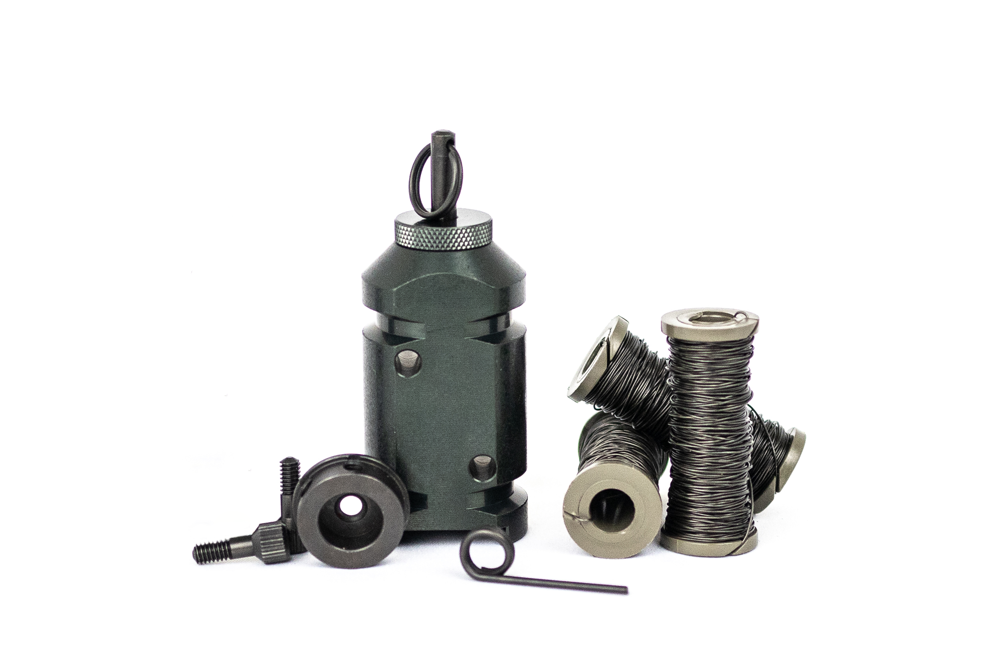 The 12g perimeter trip alarm sitting on its flat bottom, next to the 308 adapter on its side, with 3 spools of military trip wire. Complete kit for camping, hiking, backpacking